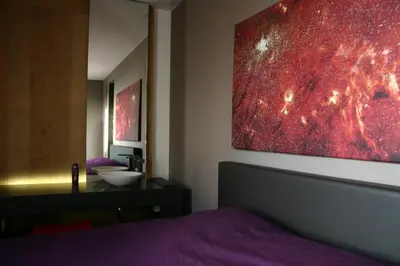 a bedroom with a bed and a painting on the wall at Loft Aan Het Water in Grobbendonk