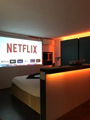 a hotel room with a bed and a sign that reads netflix at Loft Aan Het Water in Grobbendonk