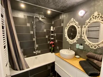 a bathroom with a tub and a sink and mirror at Grand Appartement Jourdan EU in Brussels