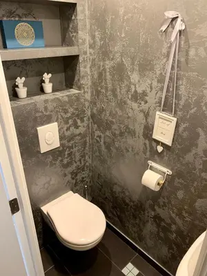 a bathroom with a toilet and a toilet paper dispenser at Grand Appartement Jourdan EU in Brussels