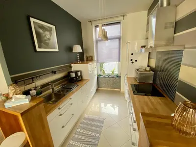 a kitchen with white cabinets and a sink and a window at Grand Appartement Jourdan EU in Brussels