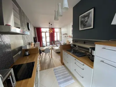 a kitchen with white cabinets and a black wall at Grand Appartement Jourdan EU in Brussels