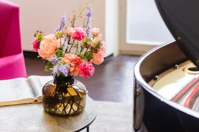 a vase filled with flowers sitting on a table at The Piano Guesthouse - Kwaadham52 in Ghent