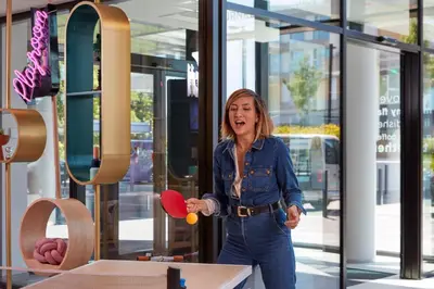 a woman is holding a ping pong racket at Adagio access Brussels Delta in Brussels