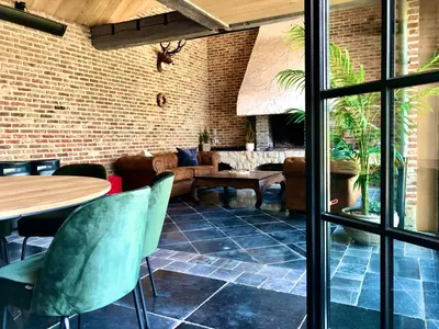 a room with a couch and a table and chairs at 't Averhuys in Itegem