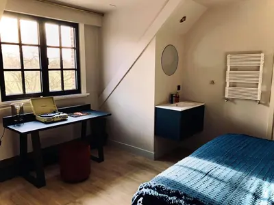 a bedroom with a bed and a desk and a sink at 't Averhuys in Itegem
