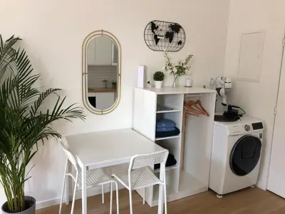 a white laundry room with a white table and a washing machine at Logement luxueux dans le coeur de Bruxelles in Brussels