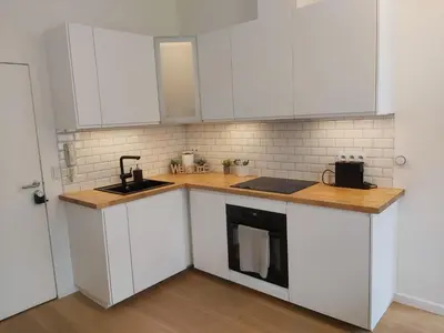 a kitchen with white cabinets and a counter top at Logement luxueux dans le coeur de Bruxelles in Brussels