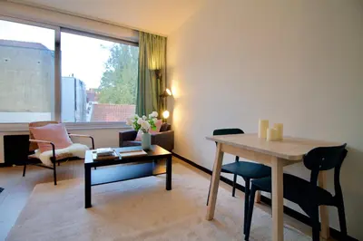 a living room with a table and chairs and a window at Amazing & cosy studio perfect location 'Stephanie-Louise area' in Brussels