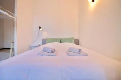 a large white bed with two pillows on it at Amazing & cosy studio perfect location 'Stephanie-Louise area' in Brussels