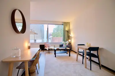 a living room with a table and chairs and a mirror at Amazing & cosy studio perfect location 'Stephanie-Louise area' in Brussels