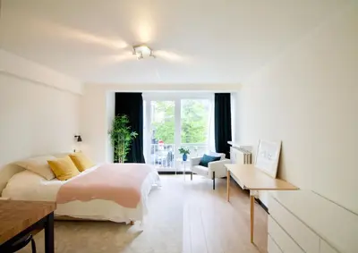a bedroom with a bed and a desk and a window at Splendid & cosy studio - perfect location 'Stephanie-Louise area' in Brussels