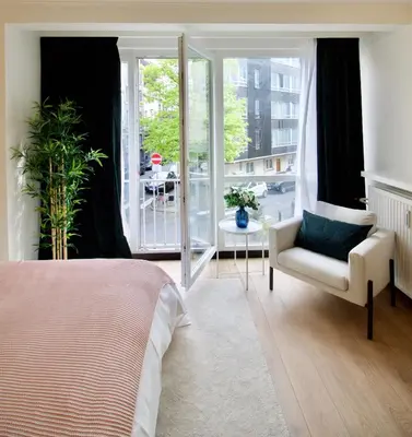a bedroom with a bed and a chair and a window at Splendid & cosy studio - perfect location 'Stephanie-Louise area' in Brussels