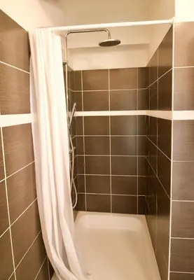 a bathroom with a bath tub with a shower curtain at Splendid & cosy studio - perfect location 'Stephanie-Louise area' in Brussels