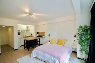 a bedroom with a bed and a small kitchen at Splendid & cosy studio - perfect location 'Stephanie-Louise area' in Brussels