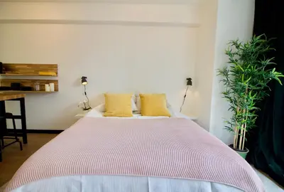 a bedroom with a large bed with yellow pillows at Splendid & cosy studio - perfect location 'Stephanie-Louise area' in Brussels