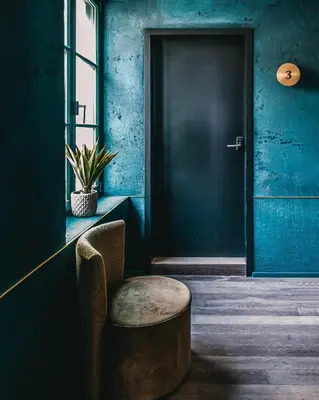 a blue room with a chair and a door at Nonam Boutique Hotel Gent in Ghent