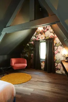 a attic room with a bed and a window at Nonam Boutique Hotel Gent in Ghent