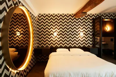 a bedroom with a large bed and a mirror at Nonam Boutique Hotel Gent in Ghent