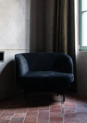 a blue couch sitting in a room with a window at Nonam Boutique Hotel Gent in Ghent