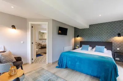 a bedroom with a bed and a living room at B&B Hof Ter Koningen in Aalst