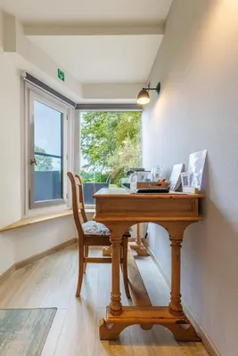 a wooden desk with a chair and a window at B&B Hof Ter Koningen in Aalst