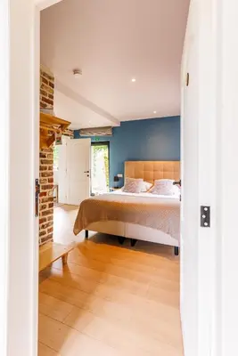 a bedroom with a bed and a brick wall at B&B Hof Ter Koningen in Aalst