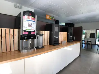 a coffee shop with a drink dispenser on a counter at HI Brussels Generation Europe Hostel in Brussels