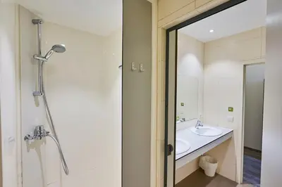 a bathroom with a shower and a sink at HI Brussels Generation Europe Hostel in Brussels