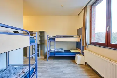 a dorm room with bunk beds and a window at HI Brussels Generation Europe Hostel in Brussels