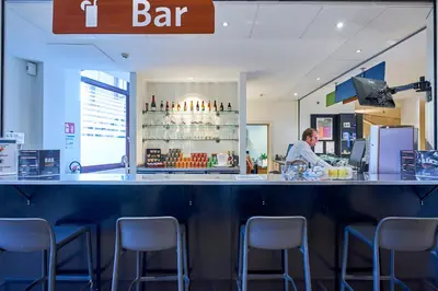 a man standing behind a bar in a restaurant at HI Brussels Generation Europe Hostel in Brussels
