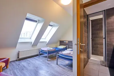a small room with a bed and a window at HI Brussels Generation Europe Hostel in Brussels