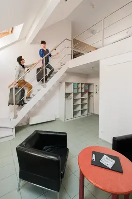 two men are climbing stairs in a building at HI Brussels Jacques Brel Hostel in Brussels