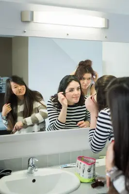 a group of women looking in a bathroom mirror at HI Brussels Jacques Brel Hostel in Brussels