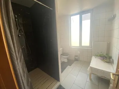a bathroom with a shower and a toilet and a window at Privé appartement in de buurt van Brussel in Asse