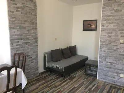 a couch in a living room with a brick wall at Privé appartement in de buurt van Brussel in Asse