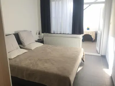 a bedroom with a bed and a large window at Private apartment near Brussels in Asse