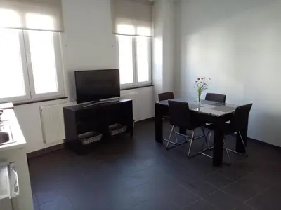 a dining room with a table and chairs and windows at Private apartment near Brussels in Asse
