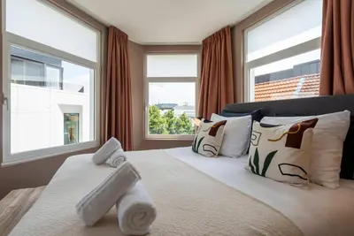 a bedroom with a large bed with windows at SHWAY - The Suit in Antwerp