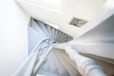 a white spiral staircase in a room with a window at SHWAY - The Suit in Antwerp