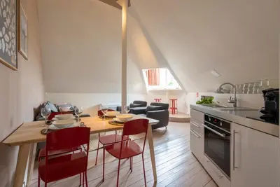 a kitchen with a table and red chairs in a room at SHWAY - The Suit in Antwerp