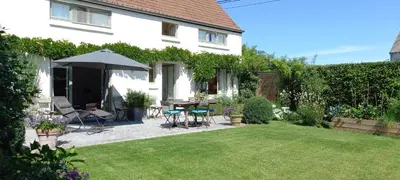 a backyard with a table and chairs and an umbrella at little cottage in Lasne