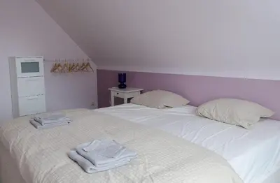 a bedroom with two beds with towels on them at De Wilgoren in Kasterlee