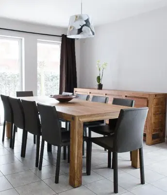 a dining room table with chairs and a table and a light at De Wilgoren in Kasterlee