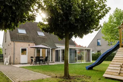 a house with a slide in the yard at De Wilgoren in Kasterlee