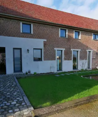 a brick house with a green lawn in front of it at Elingenhof in Elingen