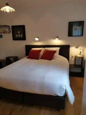 a bedroom with a large bed with two red pillows at Elingenhof in Elingen