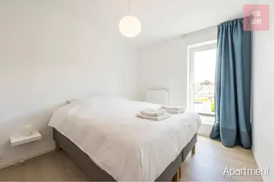 a white bedroom with a bed and a window at Lovely & Stylish accommodations at P36 Gent, near the Center in Ghent