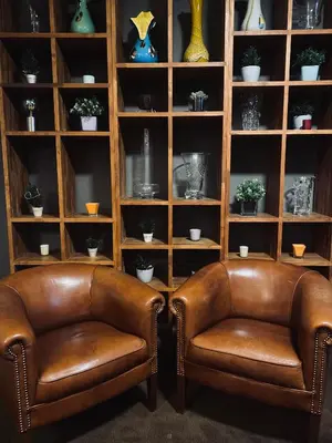 two brown leather chairs sitting in a book shelf at HOTEL BORNEM in Bornem