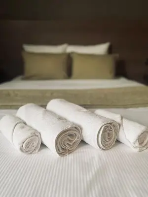 three rolled towels on a bed in a hotel room at HOTEL BORNEM in Bornem